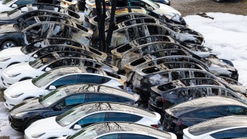 Nach einem Feuer stehen beschädigte Elektroautos auf einem Parkplatz in Frankfurt-Fechenheim. 