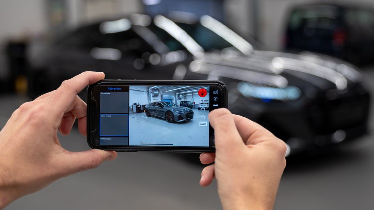 Smartphone mit der App PhotoFairy macht Fotos eines Fahrzeugs