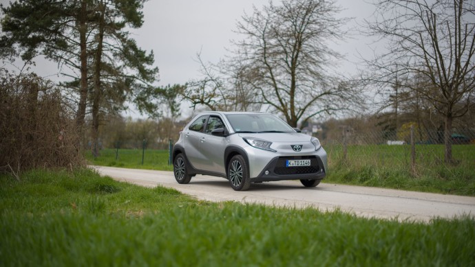 Toyota Aygo X (2023) Toyota Aygo X schraeg von vorn auf Feldweg mit Baum im Hintergrund
