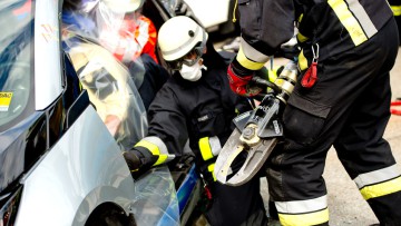 Feuerwehrmänner zerschneiden am 12. August 2014 bei einer Übung auf dem Hof des ADAC-Technikzentrum in Landsberg (Bayern) mit einer hydraulischen Rettungsschere die Karosserie von einem BMW i3. Ob Elektroautos, schwere Geländewagen, Gastanks oder neue Wer