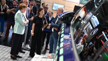 Außenministerin Annalena Baerbock besucht auf der IAA mehrere Autobauer und Zulieferer, hier spricht sie mit Markus Mildner, CEO E-Mobility von Siemens Smart Infrastructure. Links: VDA-Präsidentin Hildegard Müller.