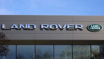 Blick auf das Logo und den Schriftzug der Automarke Land Rover an einem Autohaus