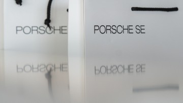 Bei der Hauptversammlung der Porsche Automobil Holding SE spiegeln sich Taschen für die Aktionäre.