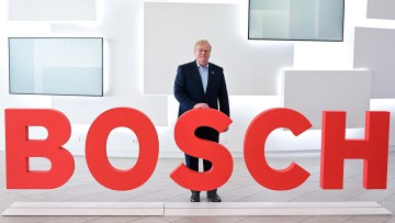 Stefan Hartung, der Vorsitzende der Geschäftsführung des Technologie-Konzerns Bosch, steht vor einem Bosch Logo. 
