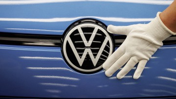 VW-Logo am Fahrzeug mit Hand