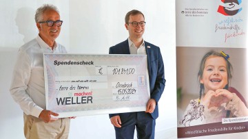 Burkhard Weller einen Jubiläums-Spendenscheck in Höhe von 101.841 Euro an Terre des hommes Vorstandsmitglied Joshua Hofert.