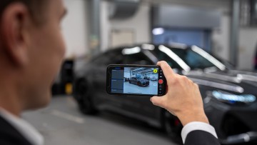 Nutzer der PhotoFairy-App macht eine Außenaufnahme eines Fahrzeugs mit seinem Smartphone