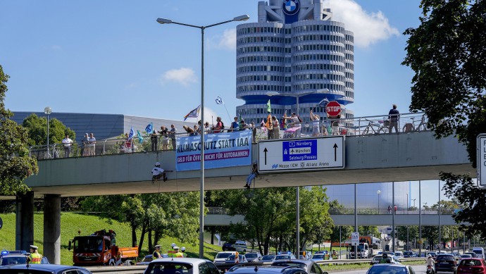 Klimaaktivisten demonstrieren vor dem BMW-Vierzylinder in München.