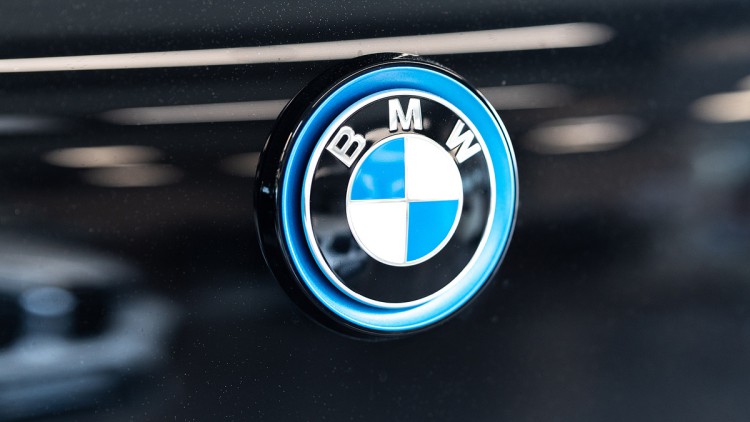 Das Logo des Autoherstellers BMW ist auf einem i3 in einem Autohaus zu sehen. 