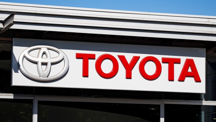 Toyota-Logo und -Schriftzug an einer Autohaus-Fassade