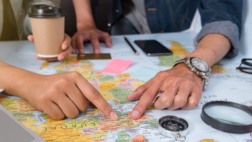 Paar, das Reiseplanung auf einer Europa-Landkarte betreibt
