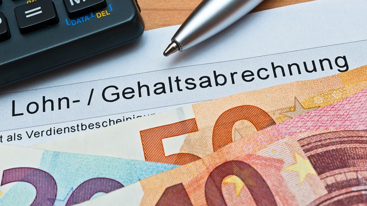 Lohnabrechnung/Gehaltsabrechung mit Euro-Scheinen und Taschenrechner und Kugelschreiber