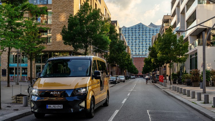 Ein Fahrzeug des Ridepoolings-Dienstes Moia in Hamburg - im Hintergrund die Elbphilharmonie