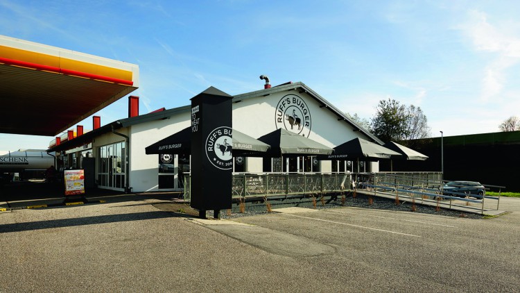 Eine Außenansicht des Restaurants Ruffs Burger neben einer Shell Tankstelle