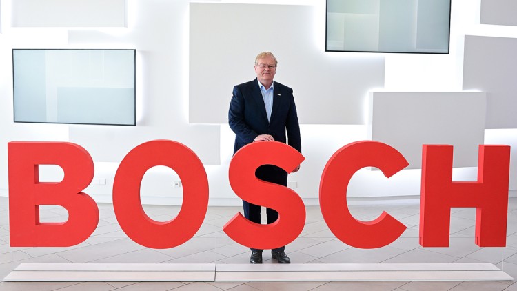 Stefan Hartung, der Vorsitzende der Geschäftsführung des Technologie-Konzerns Bosch, steht vor einem Bosch Logo. 
