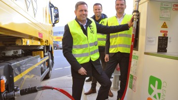 Niedersachsens Wirtschaftsminister Olaf Lies betankt einen DHL-Lkw mit Bio-CNG an der Tankstelle von OG Clean Fuels in Hannover. Hinter ihm stehen Johan Bloemsma (OG) und Marc Hitschfeld (DHL). (von links nach rechts)
