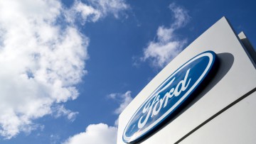 Ford Schild von untem vor blau-weißem Himmel fotografiert