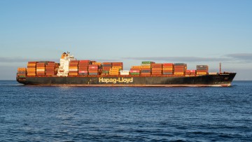 Beladenes Hapag-Lloyd Containerschiff auf dem Meer im Sonnenschein