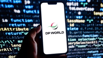 Smartphone mit DP World Logo vor Display im Hintergrund