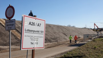 Arbeiter gehen zur Baustelle der Autobahn A26 neben der Autobahn A7 bei Hamburg