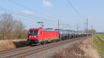 ein beladener DB Cargo Zug fährt auf den Gleisen durch die Natur
