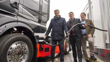 Ministerpräsident Marcus Söder, Alexander Vlaskamp von MAN Trucks&Bus und Michael Halbherr von ABB E-mobility demonstrieren das erste eTruck Megawatt-Charging