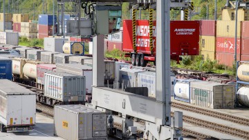 Ein kranbarer Sattelanhänger wird am DUSS-Terminal am Umschlagbahnhof München-Riem zurück auf die Straße befördert