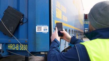 Fahrer scannt QR-Code an einem Krone-Trailer bei Lkw Walter