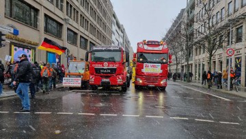 2 rote Lkws auf einer Straße in Berlin
