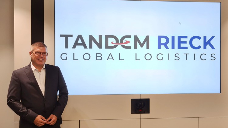 Philipp Strenge, geschäftsführender Gesellschafter der Rieck Logistik-Gruppe, vor dem neuen Logo