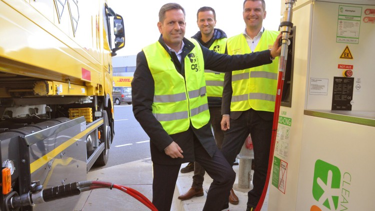 Niedersachsens Wirtschaftsminister Olaf Lies betankt einen DHL-Lkw mit Bio-CNG an der Tankstelle von OG Clean Fuels in Hannover. Hinter ihm stehen Johan Bloemsma (OG) und Marc Hitschfeld (DHL). (von links nach rechts)