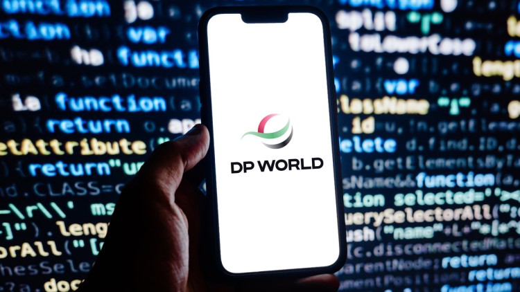 Smartphone mit DP World Logo vor Display im Hintergrund