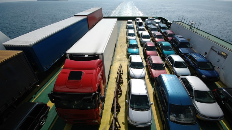 Autos und Lkw auf einer Fähre werden über ein Gewässer transportiert