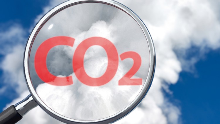 Kontrolle der CO2-Emissionen symbolisch dargestellt durch den Schriftzug "CO2" hinter einer Lupe