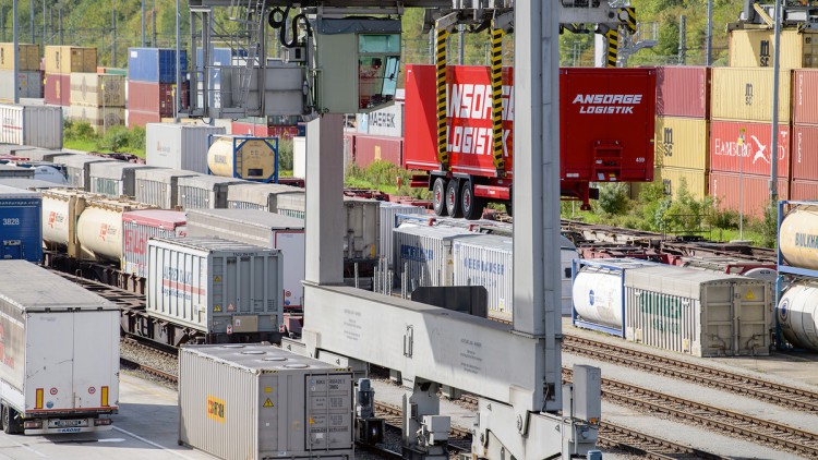 Ein kranbarer Sattelanhänger wird am DUSS-Terminal am Umschlagbahnhof München-Riem zurück auf die Straße befördert