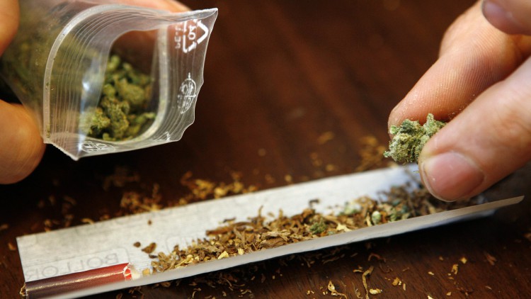 Ein Mann dreht sich einen Joint mit Marihuana (Cannabis) 